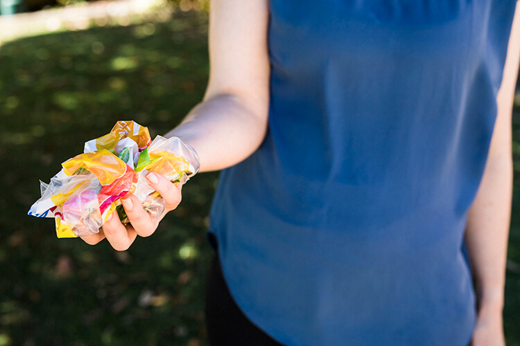 lady holding a bunch of scrunchable plastic packaging