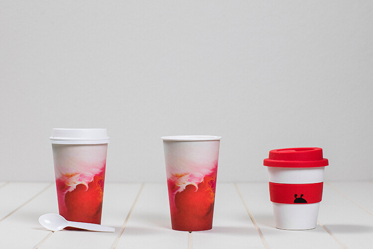 single use coffee cups next to a reusable coffee cup