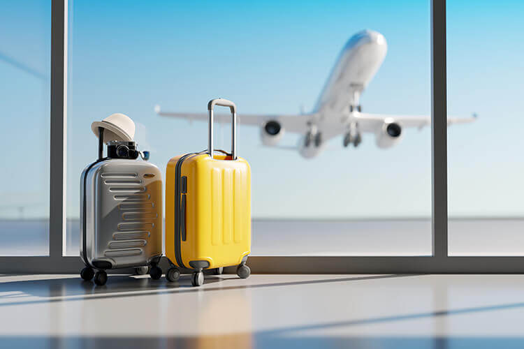 suitcases at the airport with an airplane taking off in the background