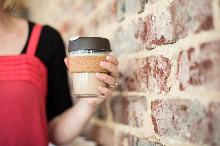 lady holding a reusable coffee cup