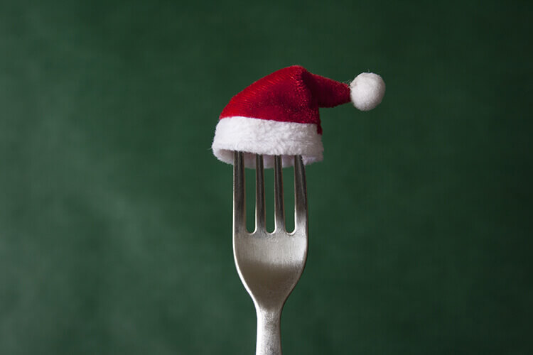 fork holding a mini santa hat