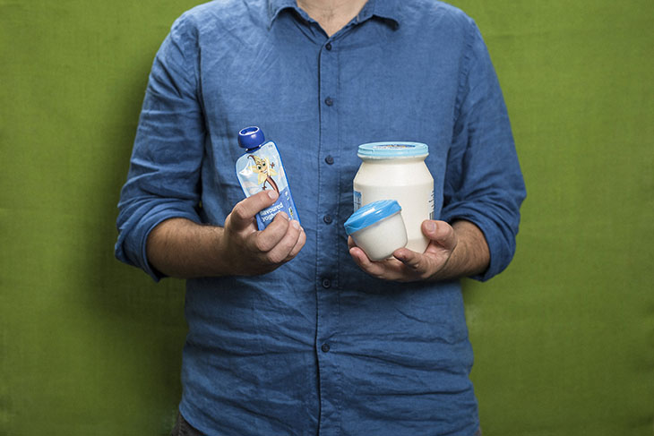 Man holding yogurt containers in different sizes