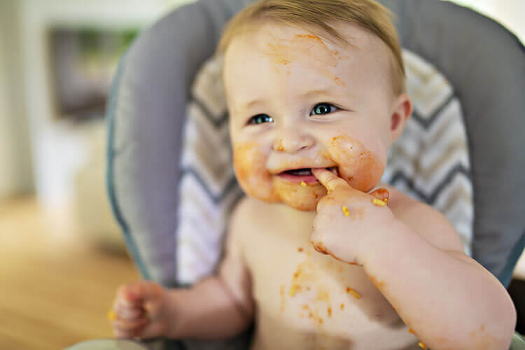 happy baby covered in food
