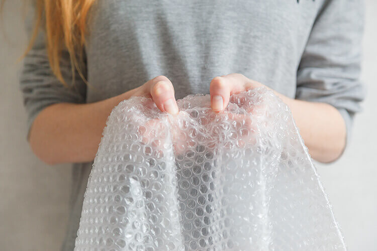 lady holding a sheet of bubble wrap