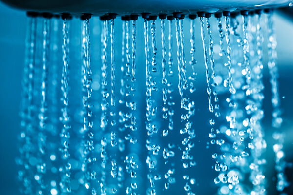 close up of a shower head with running water