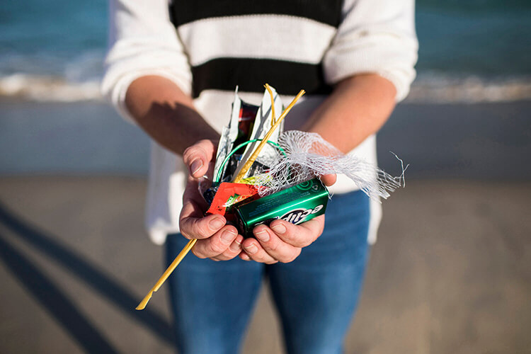close up of hands holding waste picked up at the beach