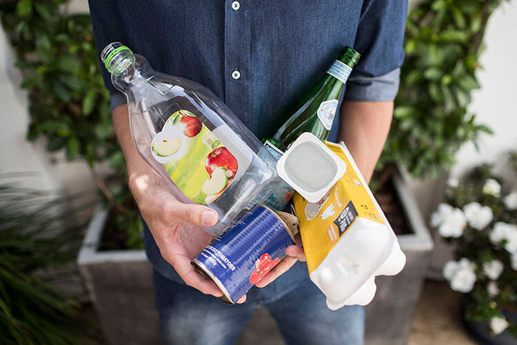 Man holding recyclable items in hands