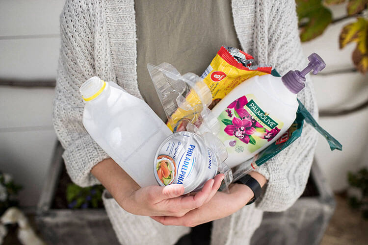 Lady holding a bunch of recyclable containers