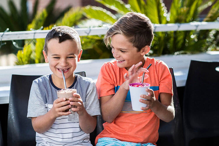 Couple of kids enjoying a smothie with reusuable straws