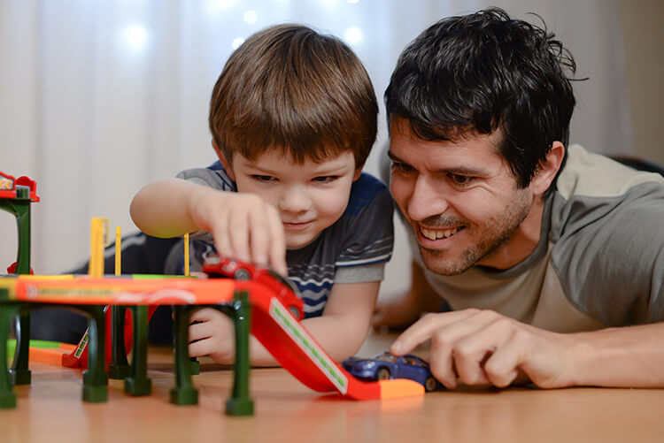 A father and son playing with toy cars