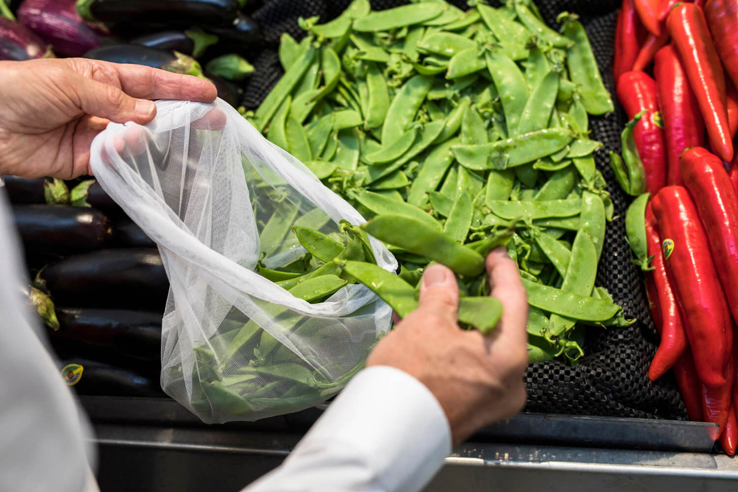 snowpeas being put in a plastic bag