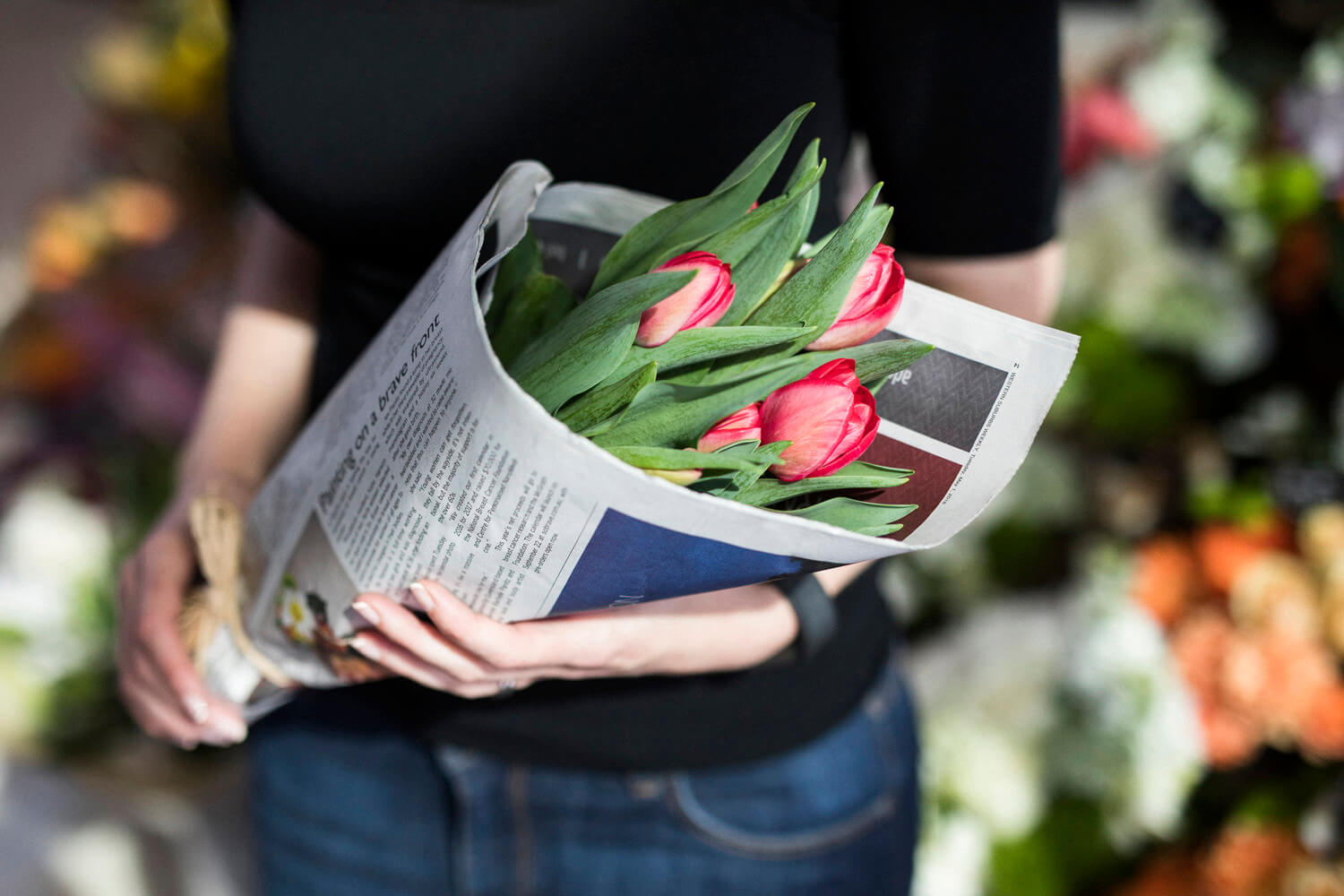 Lady holding flowers wrapped in newspaper