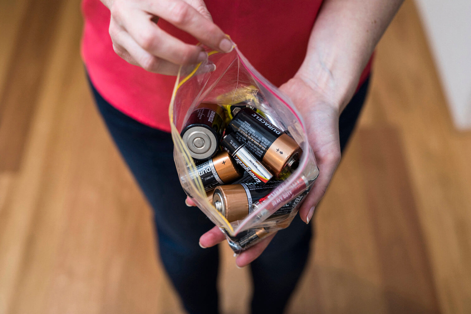 Lady holding a collection of old batteries