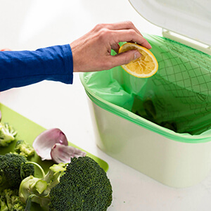 lady putting scraps in a compost bin