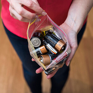 Man holding a bag of old batteries