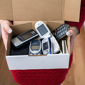 lady holding a box of old mobile phones