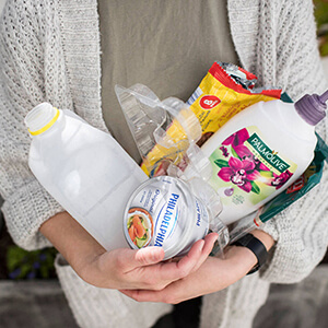 Lady holding a bunch of plastic packaging