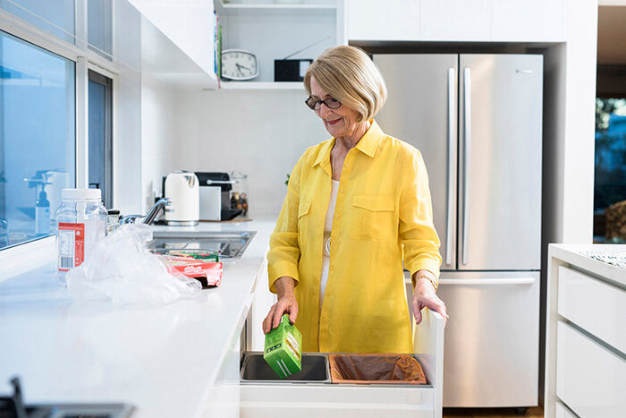 lady placing recylable container in the bin